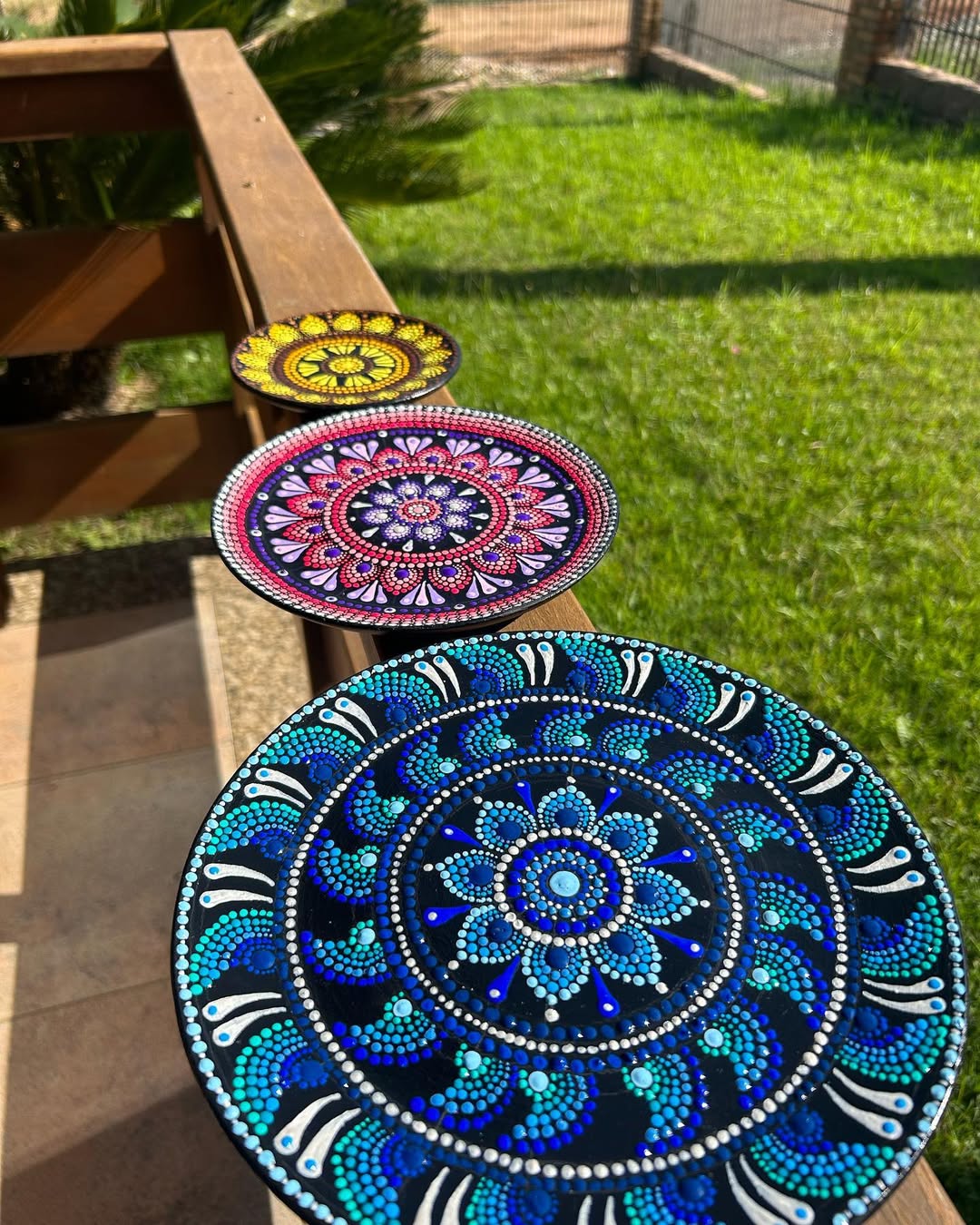 Mandalas em pontilhismo sobre pratos de madeira